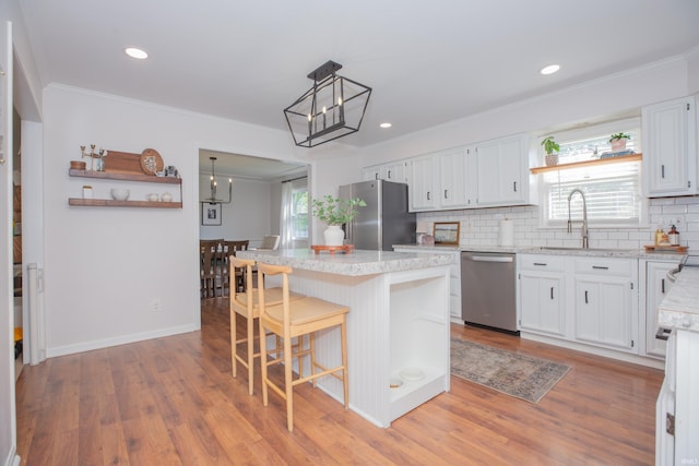 4100 Triple Crown Dr, Newburgh, IN 47630 - kitchen featuring stainless steel appliances, a sink, a kitchen island, white cabinets, and decorative backsplash