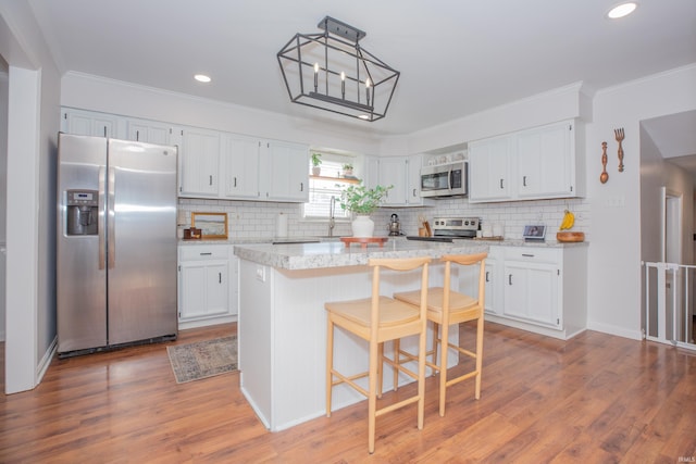 4100 Triple Crown Dr, Newburgh, IN 47630 - kitchen with appliances with stainless steel finishes, tasteful backsplash, white cabinetry, light wood-type flooring, and crown molding