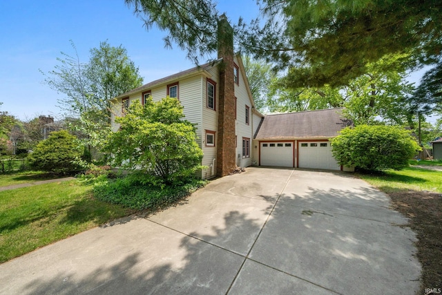 1602 Cedar St, South Bend, IN 46617 - view of home's exterior featuring driveway, a garage, a chimney, and a yard