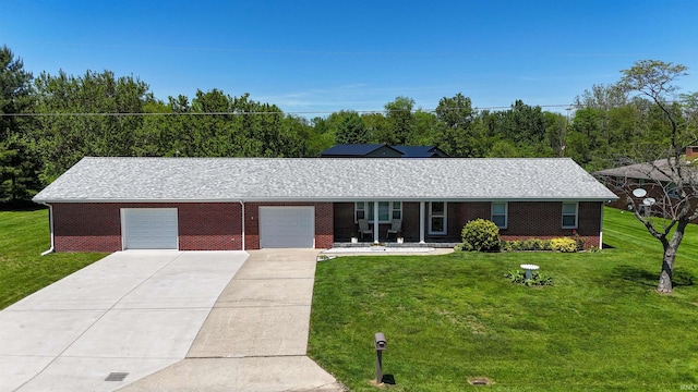 ranch-style home featuring a garage, a front yard, concrete driveway, and brick siding