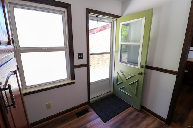 entryway with dark wood finished floors and baseboards