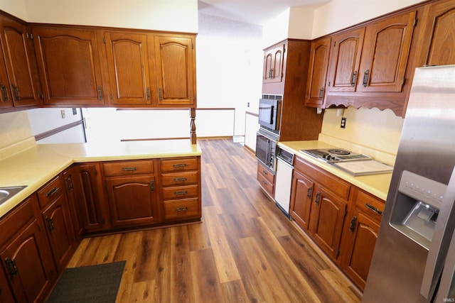 kitchen featuring stainless steel fridge with ice dispenser, light countertops, built in microwave, and dark wood-style flooring