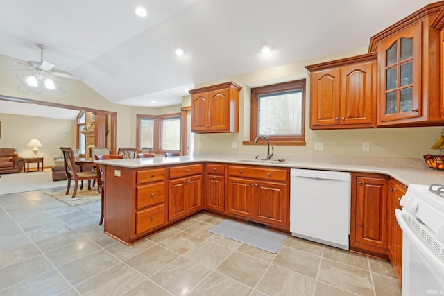 kitchen with white appliances, a sink, lofted ceiling, a peninsula, and light countertops