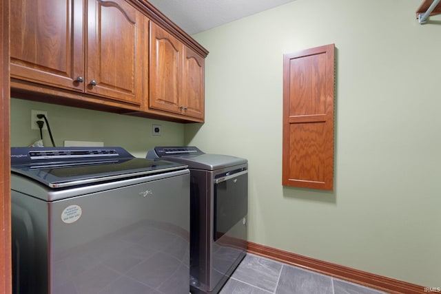 laundry area with cabinet space, washing machine and clothes dryer, baseboards, and tile patterned floors