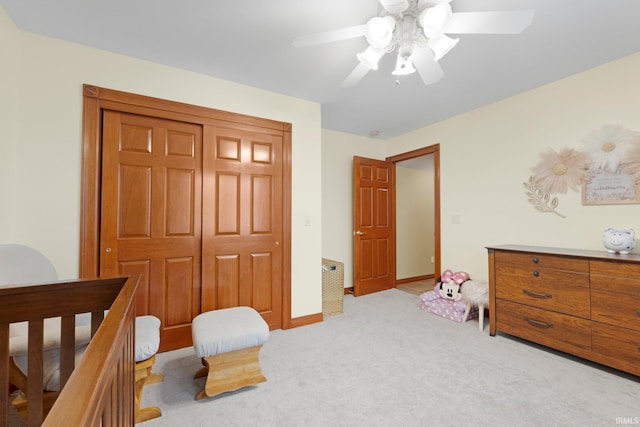 bedroom with light carpet, a closet, a ceiling fan, and baseboards