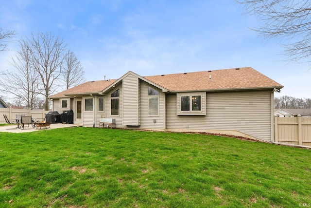 back of property with a patio and a shingled roof