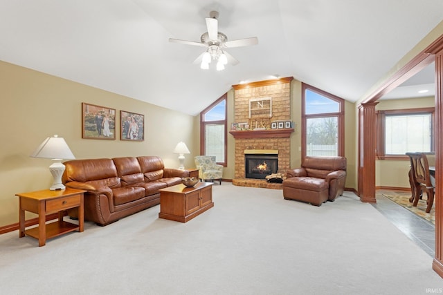 living room with vaulted ceiling, plenty of natural light, light colored carpet, a fireplace, and baseboards