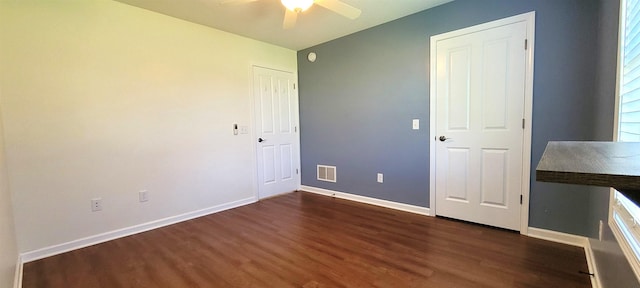 unfurnished bedroom with dark wood-type flooring, baseboards, and ceiling fan