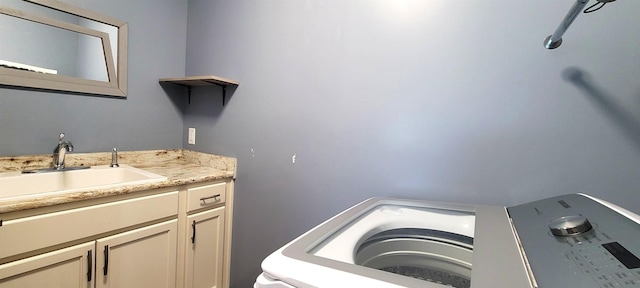 clothes washing area featuring a sink and washer / dryer