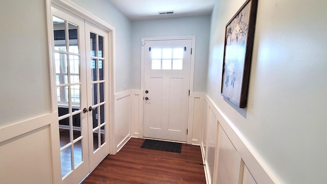 doorway featuring french doors, dark wood finished floors, and a wainscoted wall