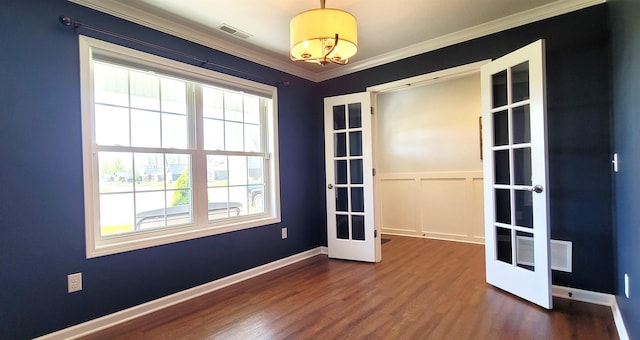 empty room featuring french doors, dark wood-style floors, crown molding, and baseboards