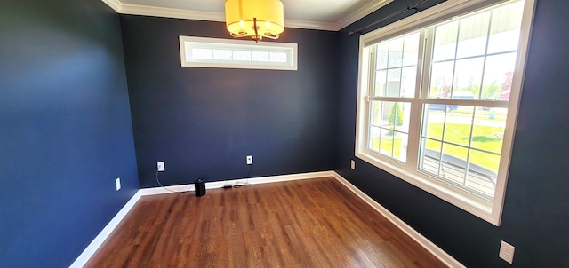 unfurnished room featuring wood finished floors, baseboards, a chandelier, and crown molding