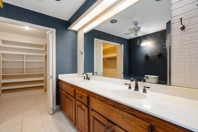 full bathroom featuring wallpapered walls, tile patterned flooring, ceiling fan, double vanity, and a spacious closet
