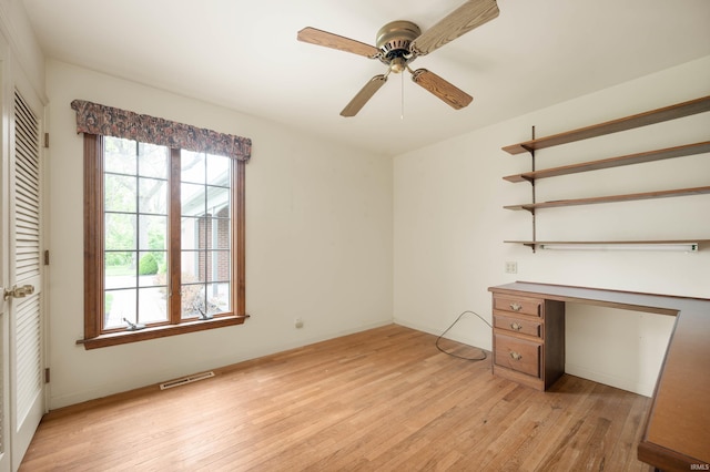 unfurnished office featuring light wood finished floors, a ceiling fan, and baseboards