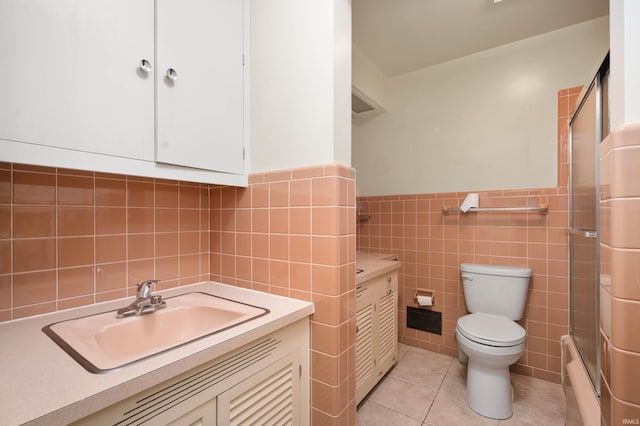 full bath featuring tile walls, an enclosed shower, toilet, tile patterned floors, and vanity