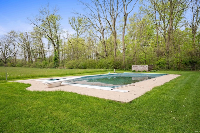 swimming pool featuring a diving board and a lawn