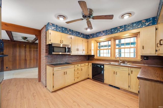 kitchen with black appliances, a sink, a ceiling fan, light wood-style floors, and dark countertops