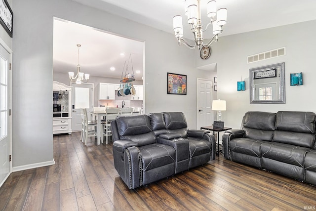 living room featuring a chandelier, dark wood-style floors, and baseboards