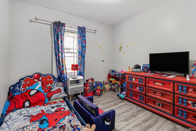 bedroom with wood finished floors and a textured ceiling