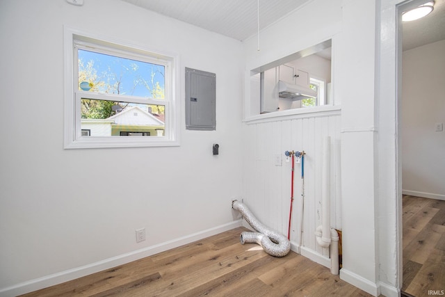 washroom featuring electric panel, light wood-style flooring, and baseboards