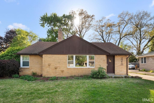 221 S Ironwood Dr, South Bend, IN 46615 - view of front of house featuring brick siding, a front lawn, a chimney, and roof with shingles