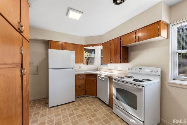 221 S Ironwood Dr, South Bend, IN 46615 - kitchen featuring white appliances, brown cabinets, a sink, light floors, and light countertops
