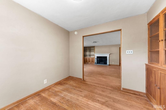 221 S Ironwood Dr, South Bend, IN 46615 - empty room featuring light wood-style flooring, baseboards, a fireplace, and a smoke detector