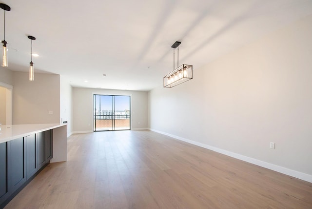 unfurnished dining area featuring light wood-type flooring and baseboards