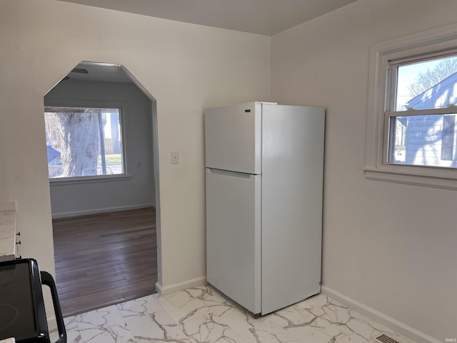 1926 E 17th St, Muncie, IN 47304 - kitchen featuring freestanding refrigerator, light marble finish flooring, and baseboards