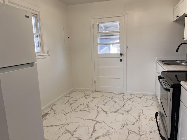 1926 E 17th St, Muncie, IN 47304 - kitchen featuring freestanding refrigerator, a sink, stainless steel electric stove, light marble finish floors, and plenty of natural light