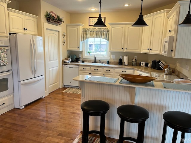 6425 E Wellston Dr, Bloomington, IN 47408 - kitchen with white appliances, a sink, a peninsula, hanging light fixtures, and recessed lighting