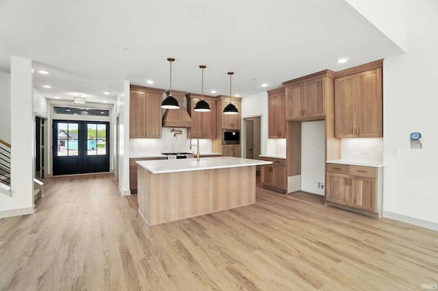 13222 Malfini Trl, Fort Wayne, IN 46845 - kitchen featuring stainless steel microwave, light wood-style floors, light countertops, recessed lighting, and a center island with sink