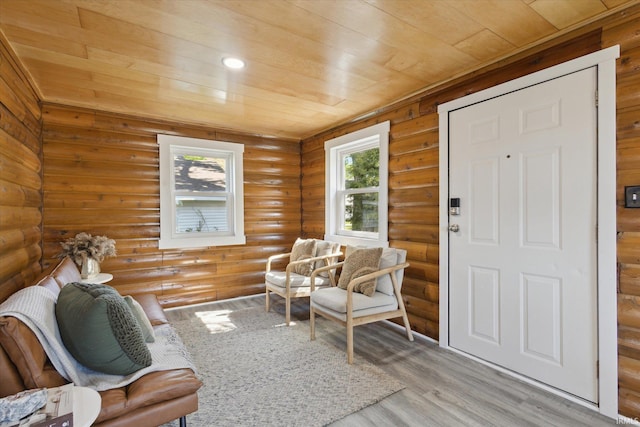 living area with wooden ceiling, wood finished floors, and log walls