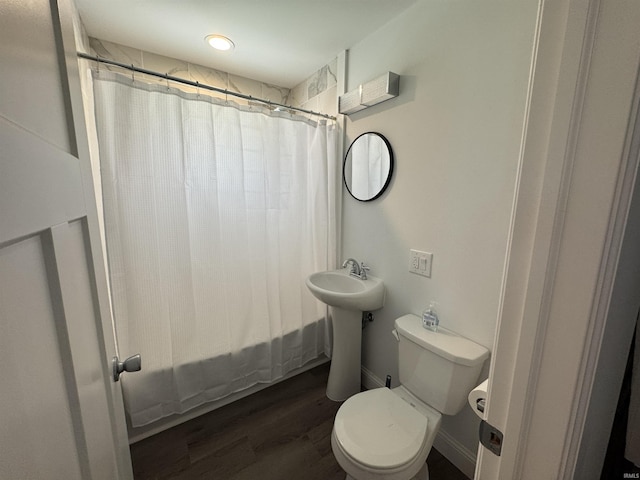 bathroom featuring toilet, wood finished floors, and shower / bathtub combination with curtain
