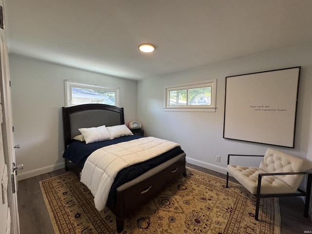 bedroom featuring multiple windows, dark wood-type flooring, and baseboards