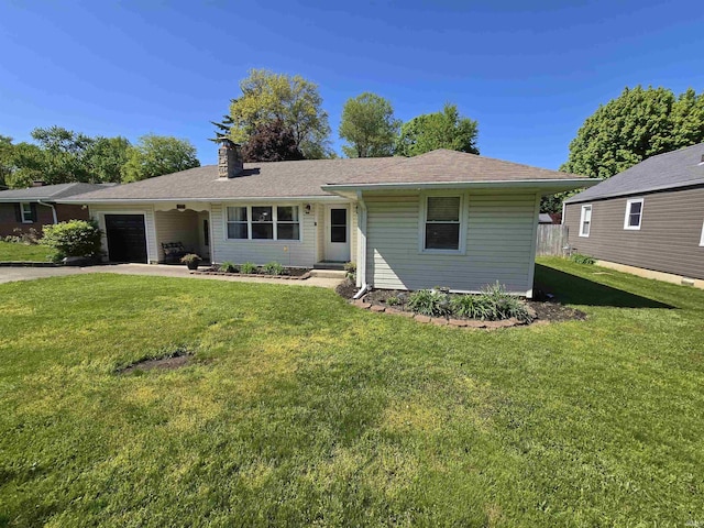 view of front of property featuring a garage, a chimney, a front lawn, and asphalt driveway