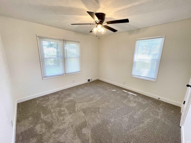spare room featuring a ceiling fan, a textured ceiling, carpet floors, and baseboards