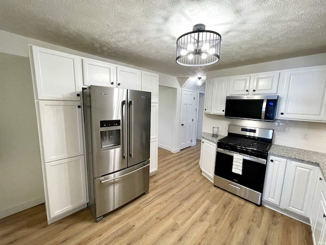 kitchen featuring appliances with stainless steel finishes, white cabinetry, and a textured ceiling