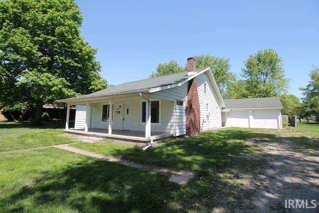 128 E Washington St, Williamsport, IN 47993 - ranch-style house with a porch, a chimney, a front yard, and a detached garage