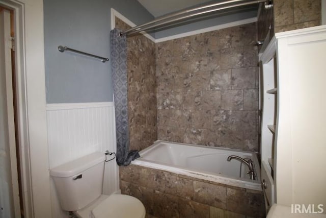 128 E Washington St, Williamsport, IN 47993 - full bathroom with wainscoting, toilet, and tiled shower / bath