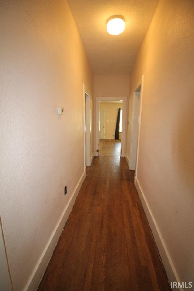 128 E Washington St, Williamsport, IN 47993 - corridor featuring dark wood-type flooring and baseboards