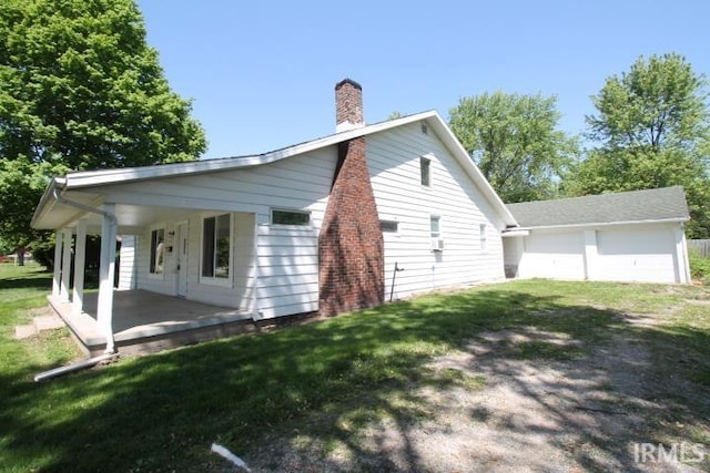 128 E Washington St, Williamsport, IN 47993 - view of property exterior with a chimney, a garage, and a yard
