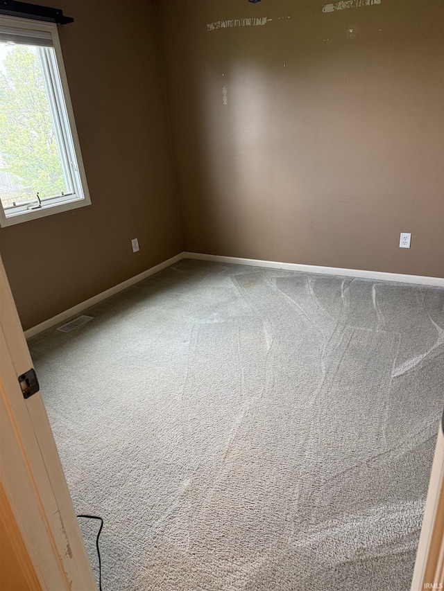 carpeted empty room featuring baseboards