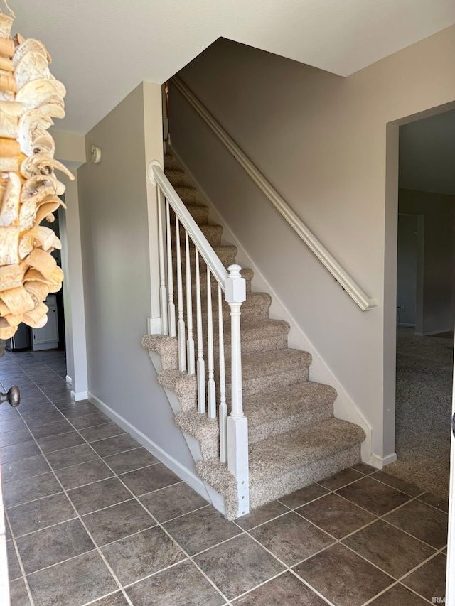 stairway featuring tile patterned flooring and baseboards
