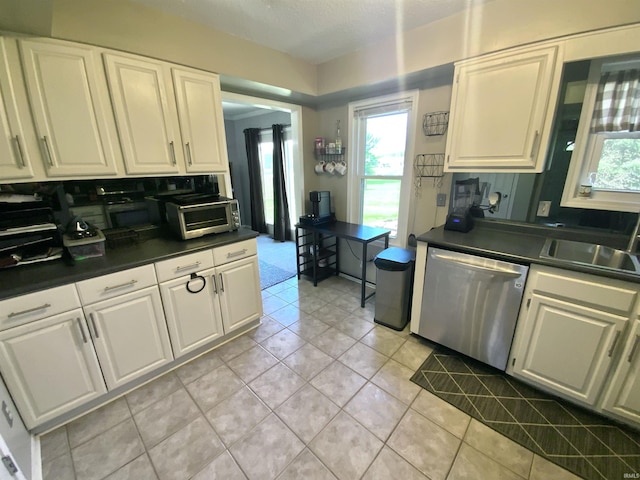 1108 Silver Springs Ct, Fort Wayne, IN 46825 - kitchen featuring stainless steel dishwasher, a sink, light tile patterned floors, and white cabinets