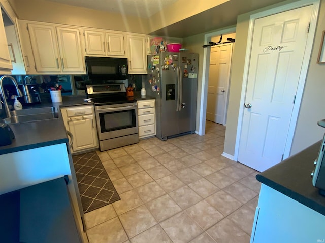 1108 Silver Springs Ct, Fort Wayne, IN 46825 - kitchen with appliances with stainless steel finishes, dark countertops, a sink, white cabinetry, and light tile patterned flooring