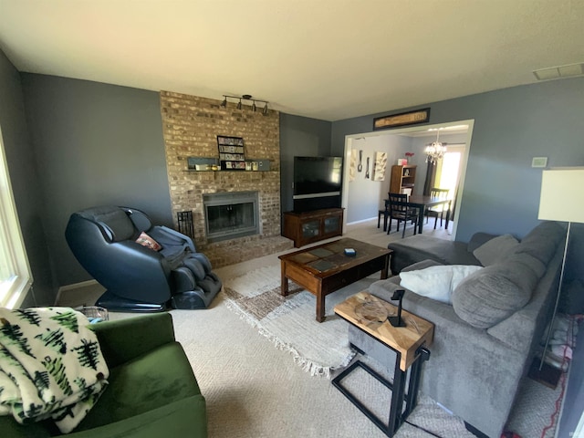 1108 Silver Springs Ct, Fort Wayne, IN 46825 - living room featuring a brick fireplace, baseboards, rail lighting, a chandelier, and carpet flooring