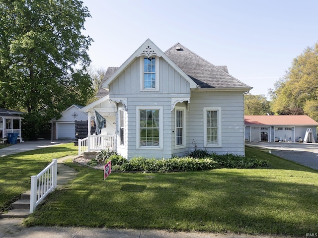 47 E Center St, Williamsport, IN 47993 - view of front of house featuring an outbuilding, board and batten siding, a front yard, and a shingled roof