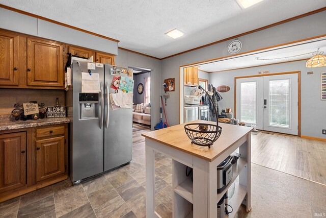 47 E Center St, Williamsport, IN 47993 - kitchen featuring stainless steel refrigerator with ice dispenser, ornamental molding, brown cabinets, french doors, and washer / dryer