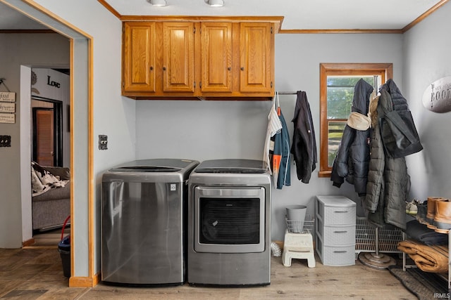 47 E Center St, Williamsport, IN 47993 - laundry room featuring independent washer and dryer, cabinet space, crown molding, and light wood finished floors